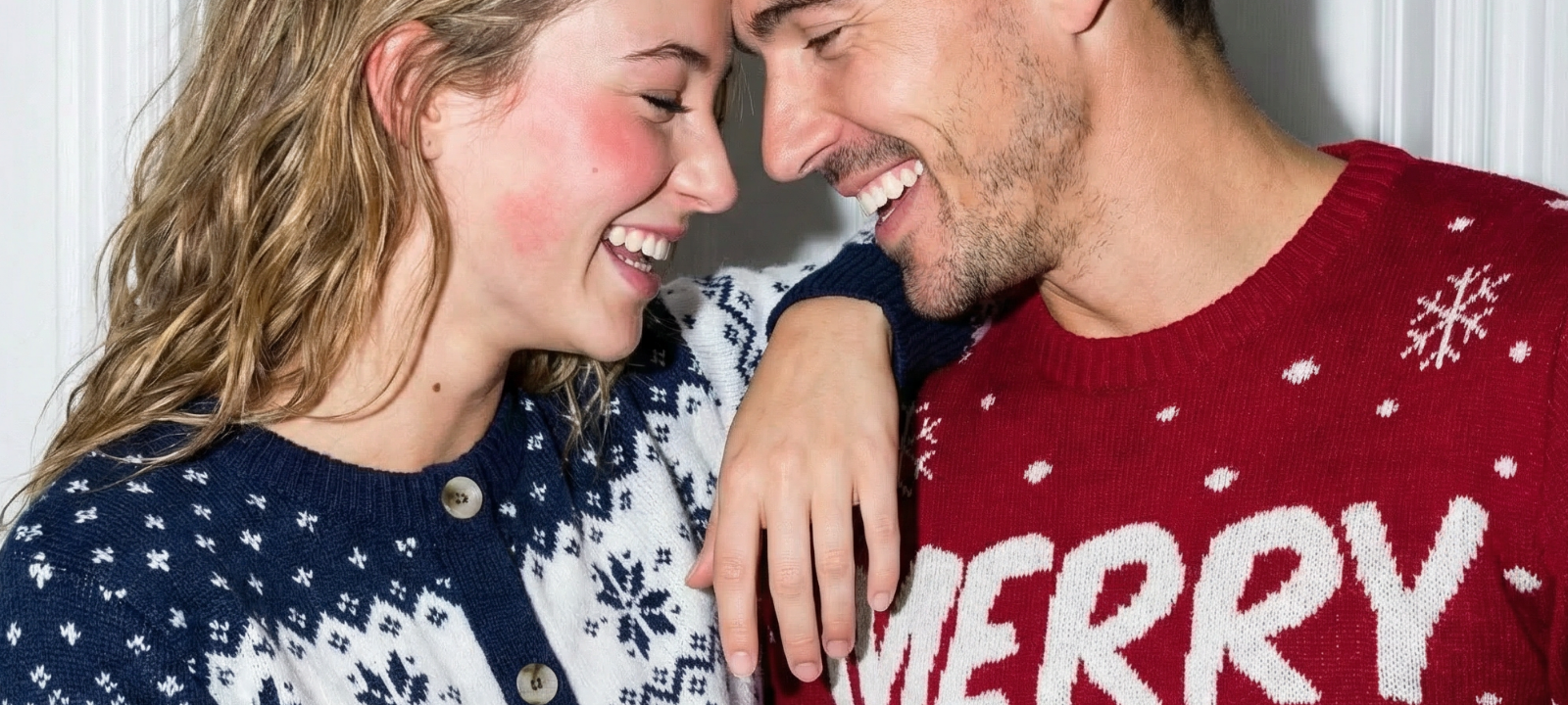 Smilende par i julegensere, hun i blå og hvit, han i rød med teksten Merry – inspirasjon til julegaver